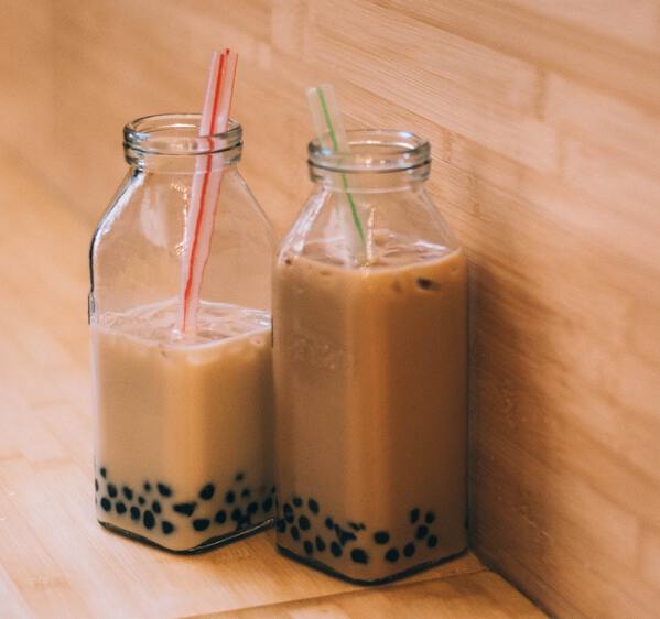 boba in glass jars sitting against wood paneling